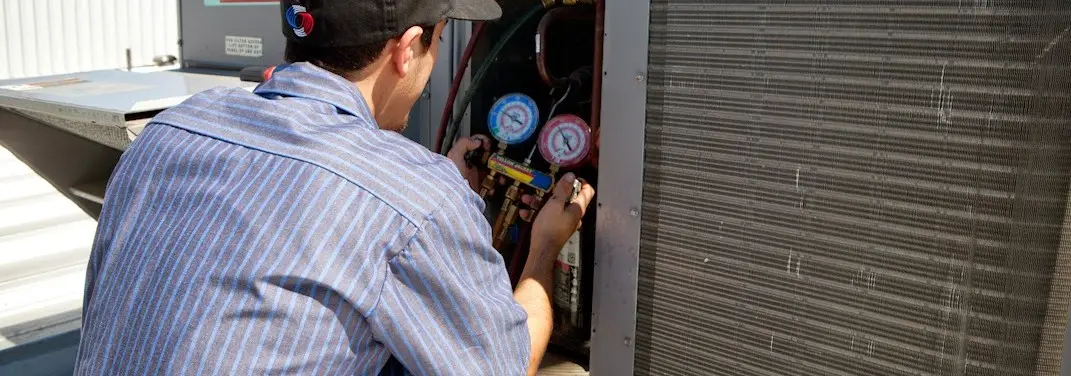 HVAC technician servicing a condenser unit in Zephyrhills West